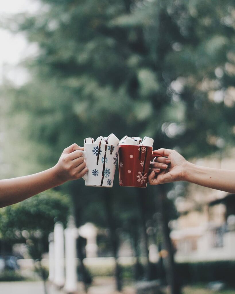 Two hot coco and marshmellow cups together