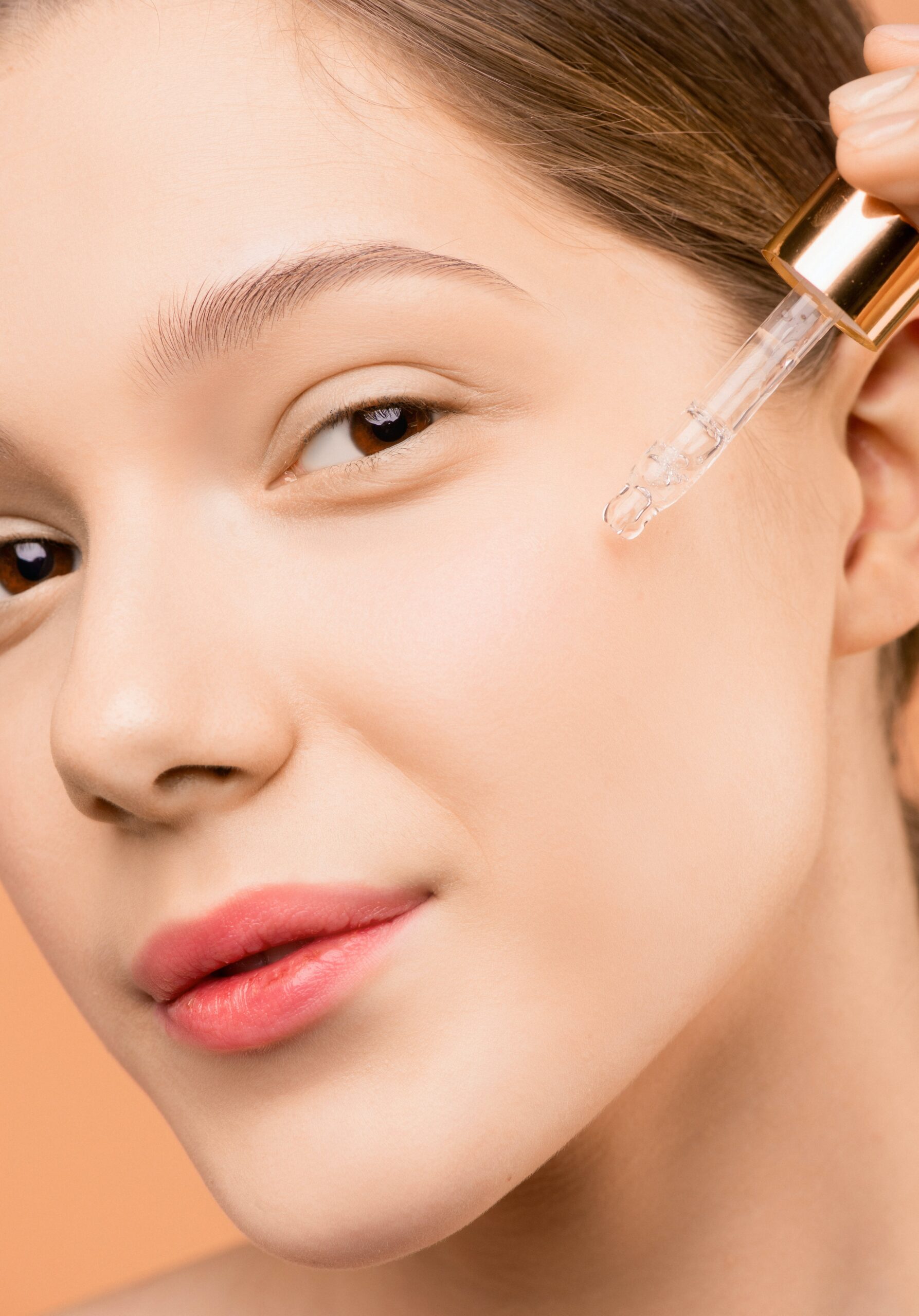 effective skincare routine woman applying serum to skin with eye dropper