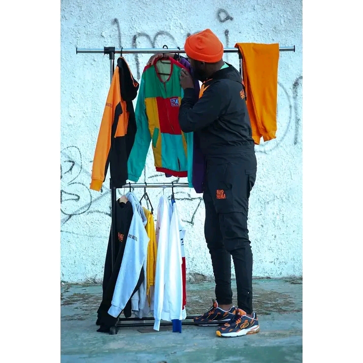 South African streetwear man arranging clothes on the street