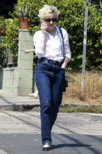 Julia Garner in a white shirt and a jeans
