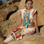 Girl sitting wearing Native American fashion