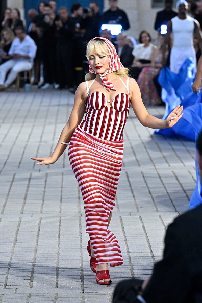  Sabrina Carpenter in red striped outfit struting 