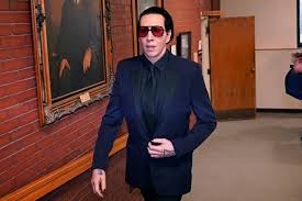 Marilyn Manson blue suit accessorized with his shades