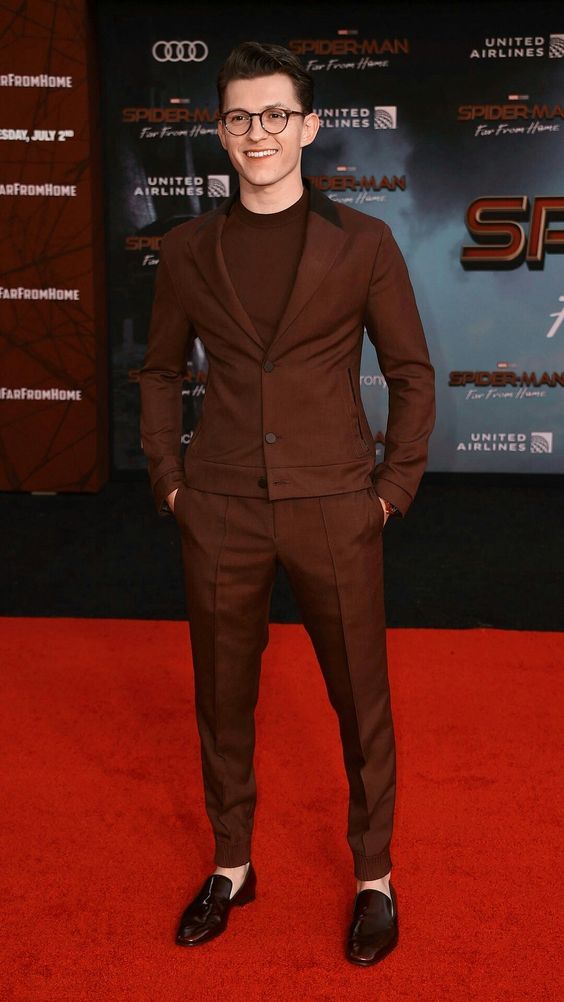 Tom Holland Fashion on the red carpet in burgundy suit 