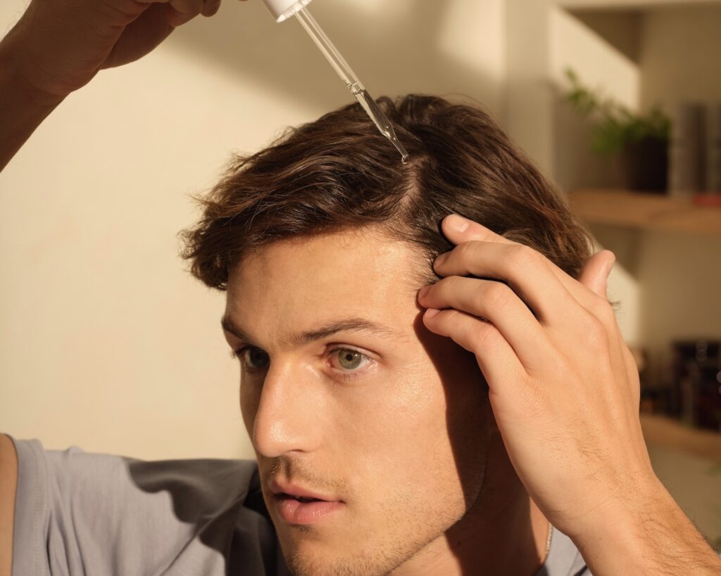 Hims hair loss treatments man applying product