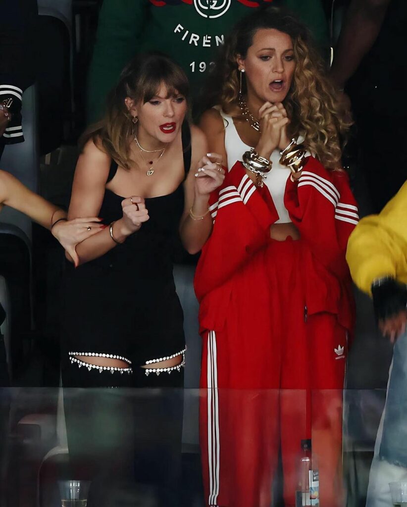 Taylor Swift Fashion Choices for football, in black sleeveless top with black pants with peekaboo