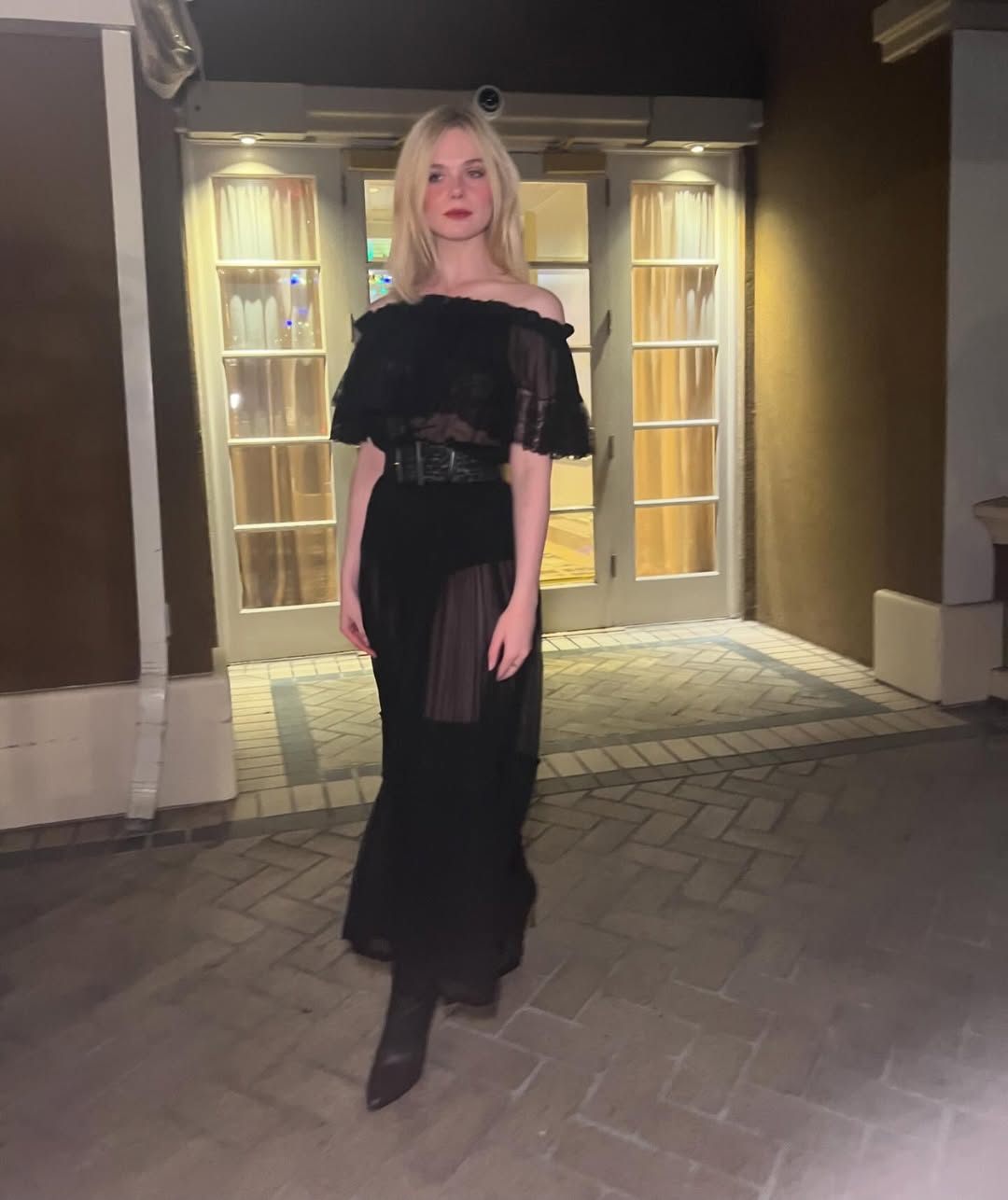 Elle Fanning is wearing a Saint Laurent sheer dress during the Los Angeles premiere of “A Complete Unknown” on December 9th, 2024, at Fox Studio Lot in California.