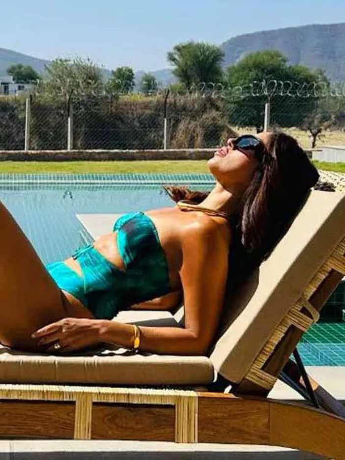 Bhumi Pednekar Bikinis You Can't-Miss laying in sun in green gradient bikini