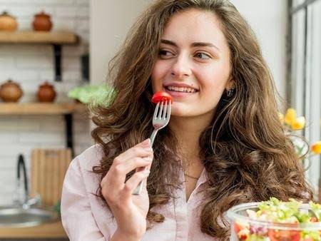 girl eating tomato with radiant skin