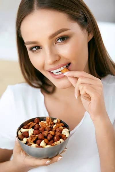 Girl with radiant skin eating nuts