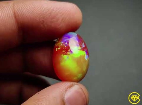 two fingers holding Ethiopian opals