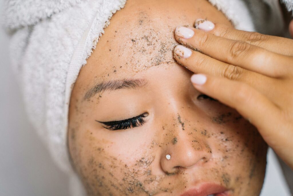 Woman applying skincare facial scrub