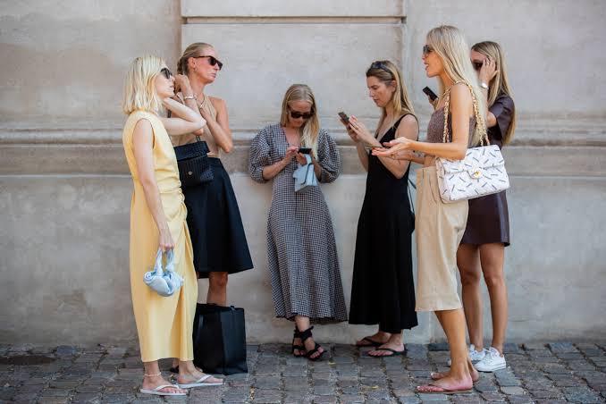  Scandi Chic girls in group using their telphones 
