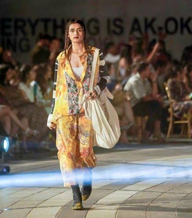 Model in yellow outfit with big bag