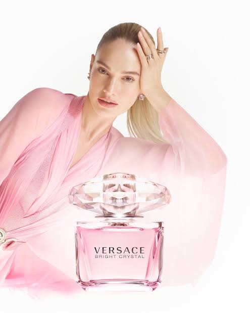 girl in pink behing Versace perfume 