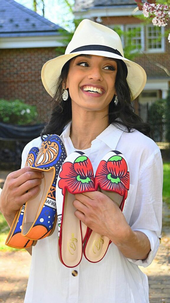 Girl in bright wite hat and top holding bright colored slippers