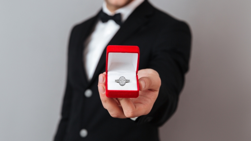 halo engagement rings man holding ring in a box
