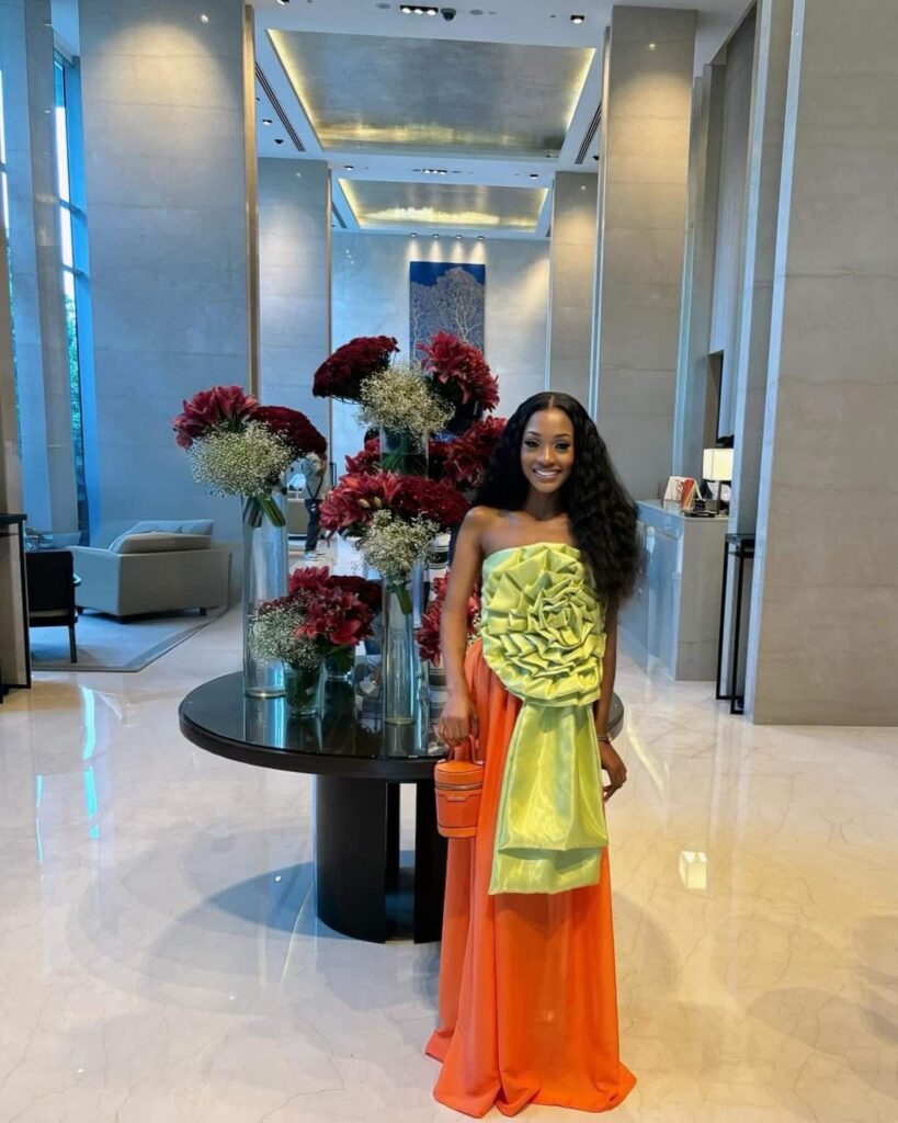 Faith Bwalya in orange and green dress