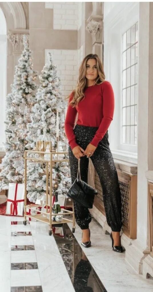 Woman wearing holiday party outfits cinch ankle pants with red sweater