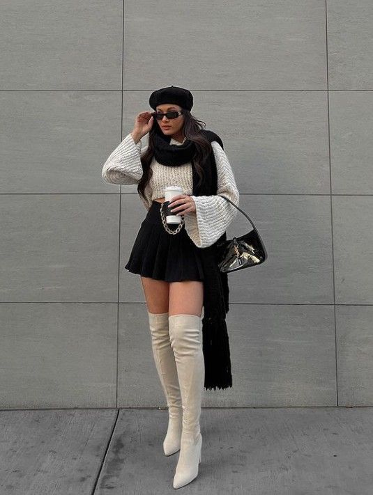 Woamn in singlasses and white knee-high boots