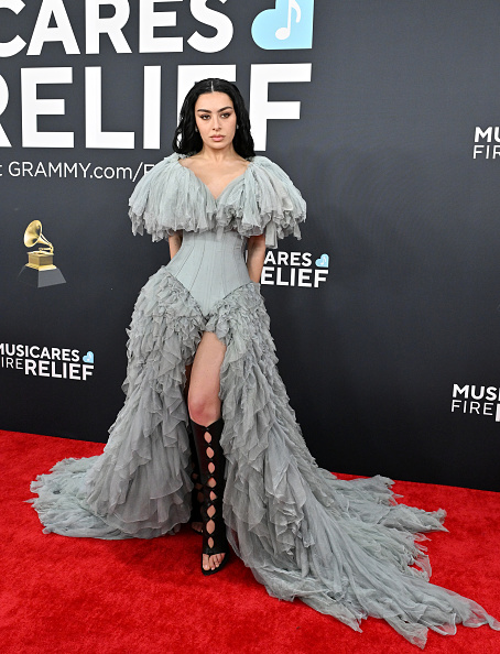 Charli XCX attended the 2025 Grammy Awards dressed in a couture Jean Paul Gaultier Haute Couture silk tulle gown and knee-high stiletto gladiator boots.