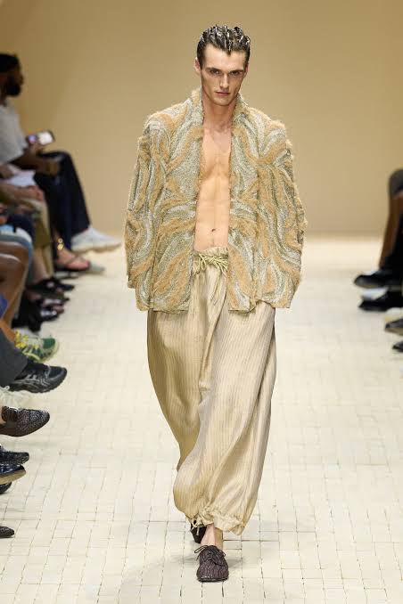 Male model in satin pants and open type jacket on the runway at Milan Fashion Week