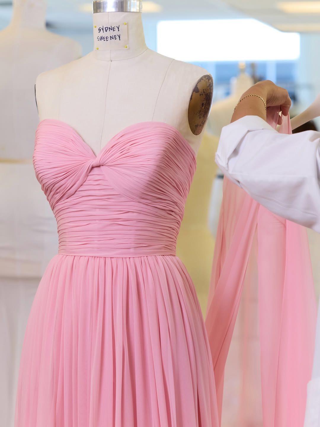 Oscar de la Renta designed a blush pink silk chiffon gown with a hand-fluted bodice and draped skirt for Sydney Sweeney to wear to the Jeff Bezos and Lauren Sanchez wedding ceremony in Venice
