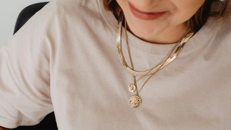 woman in biege shirt wearing a custom made necklace