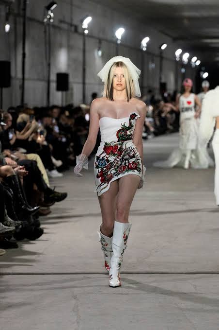 model wearing white mini dress and a boots with viel at the Berlin Fashion Week 2025