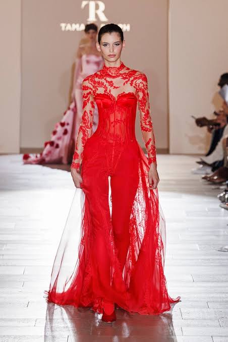 model wearing a red flowy lace jumpsuit at the Paris Haute Couture Show