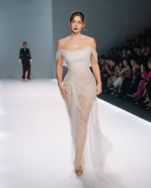 model in the runway wearing sheer gown