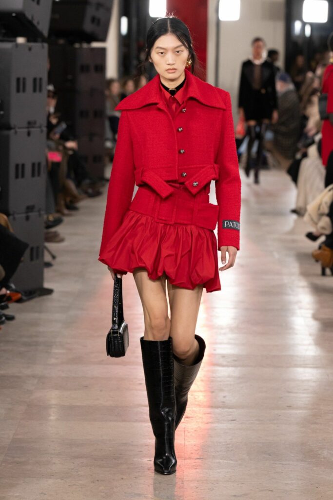 A model walks the Patou Fall/Winter 2025/2026 ready-to-wear runway collection show in a scarlet ensemble