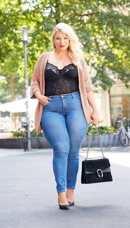 Woman in tight jeans, lace bodysuit and long pink swaeter  plus-size outfits