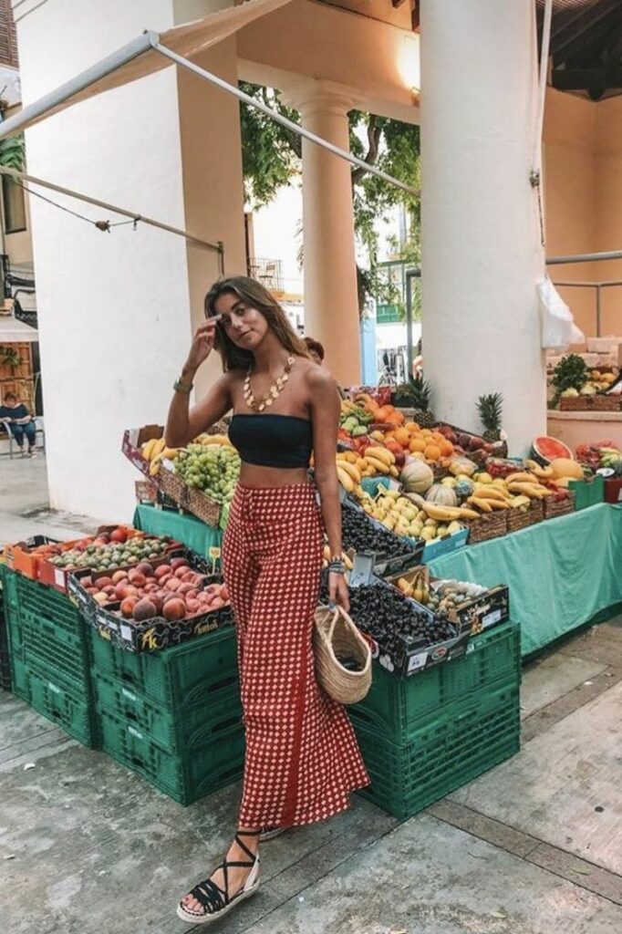 Girl in red pants and black tube top wearing rope sandals