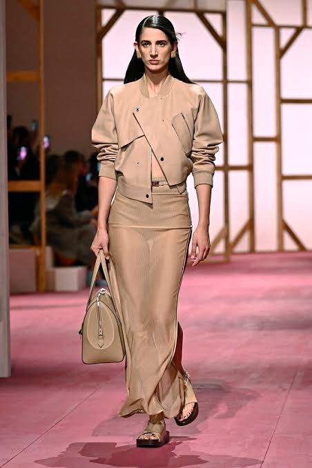 Model on runway in biege outfit 