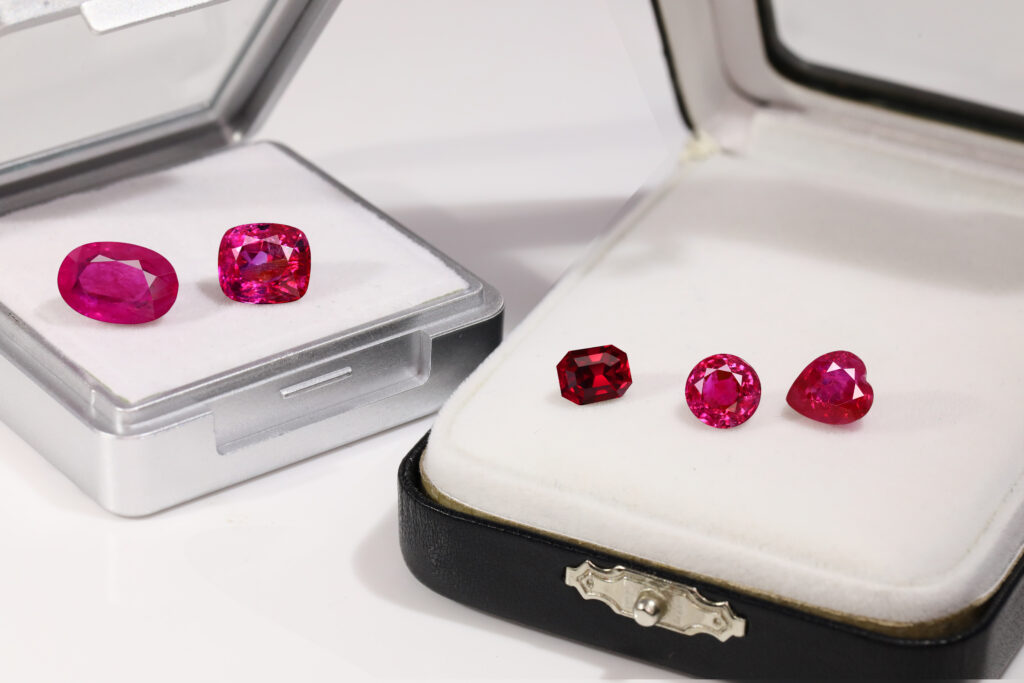 several ruby gemstones in boxes