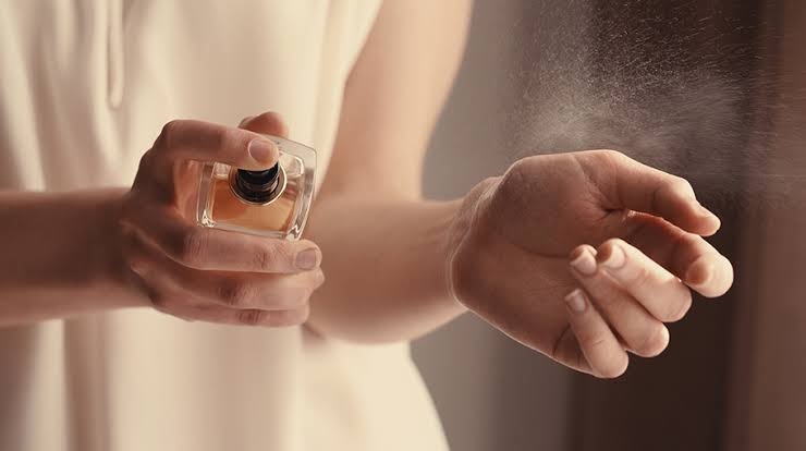 hands spraying perfume 