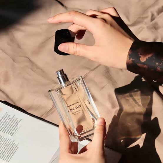 Hands holding One Day Perfume bottle 