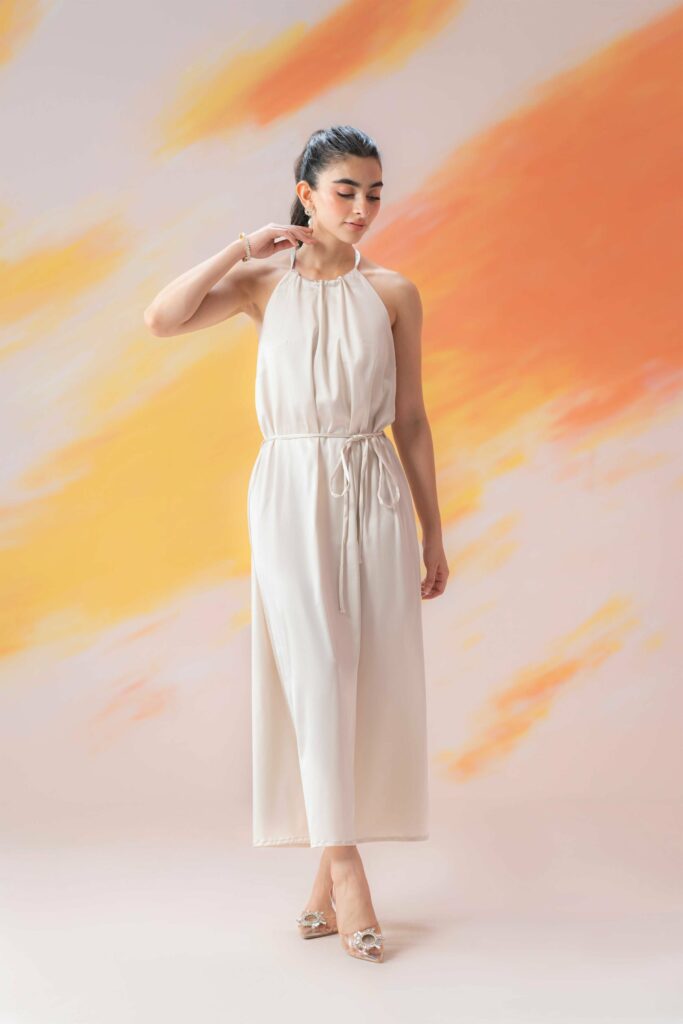 Girl in white dress on orance gradient background western dress for girls in Pakistan