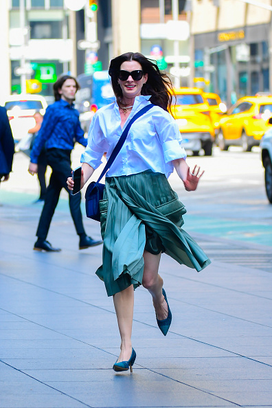 Anne Hathaway in blue blouse and green skirt New York
