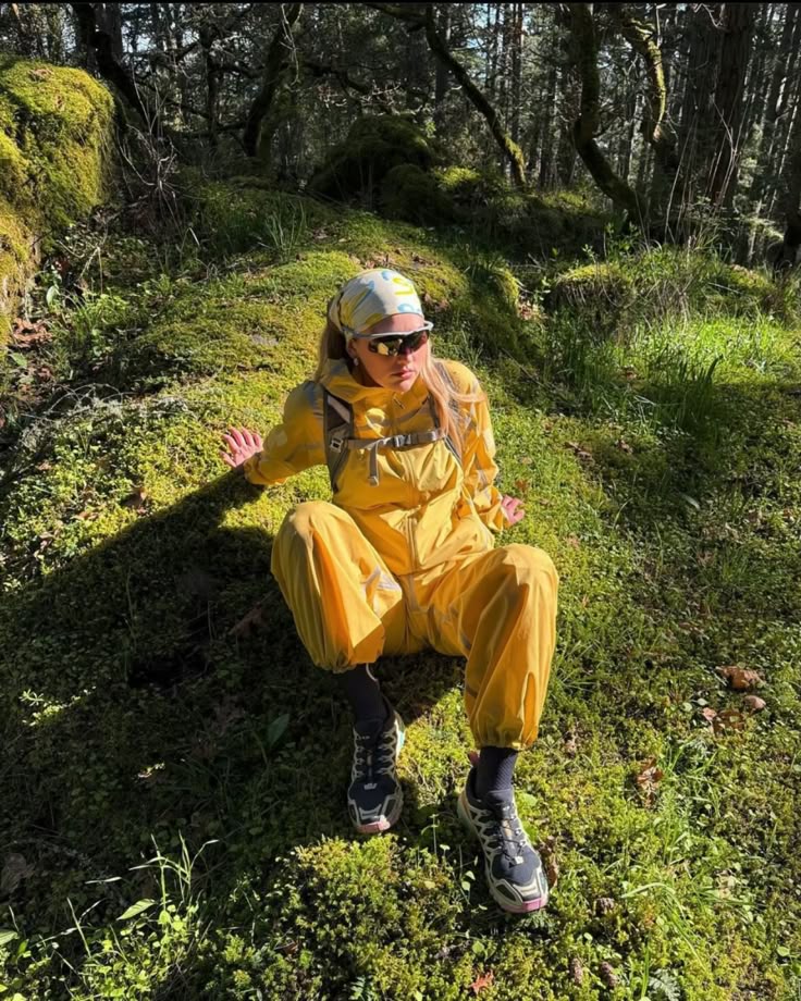 Girl laying on gorund wearing yellow Cocktail Gorpcore jumpsuit