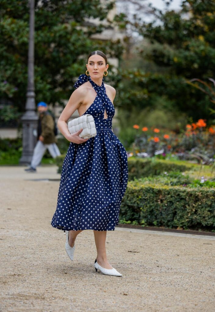woman in dark blue cris cross top Polka dots dress