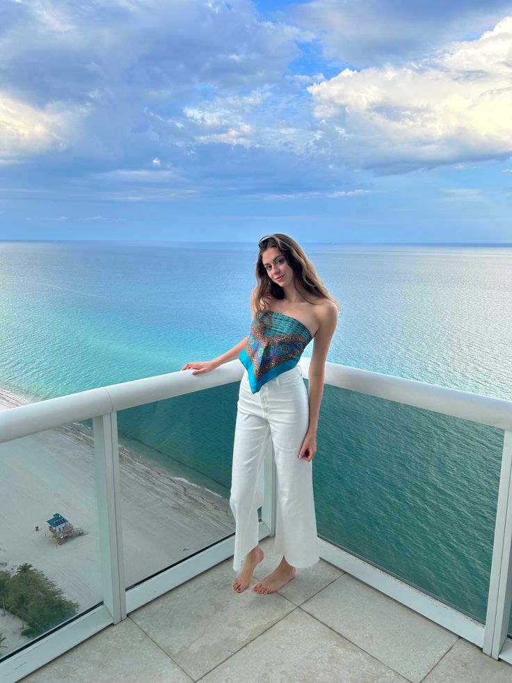 Woman wearing Silk scarves in front of ocean scene