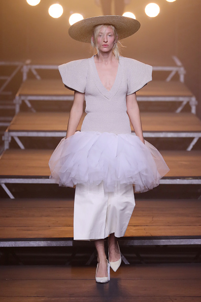 A fashion model walks down the runway during the Jacquemus Spring/Summer 2017 collection presentation, wearing a white midi dress.