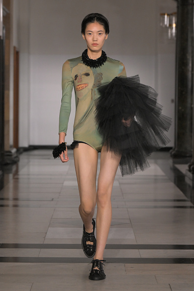 Hejia Li walks down the runway in Simone Rocha’s Spring/Summer 2025 collection, wearing a green long-sleeved bodysuit with a stunning pattern that Jenna Ortega wore on the “Wednesday” Season 2 Seoul press tour.