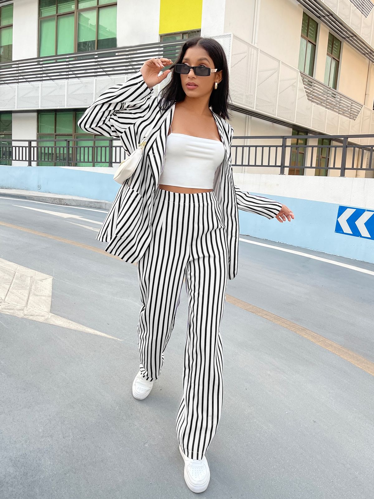 Jenna Ortega in white tube top, white and black striped blazer and pants