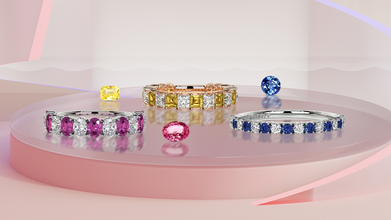 3 sapphire eternity bands on display on pink backround