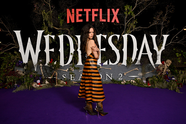Jenna Ortega at the “Wednesday” Season 2, Part 2 Press Tour in Sydney, wearing a Fendi A-line spaghetti strap midi dress with black and burnt orange chevrons.
