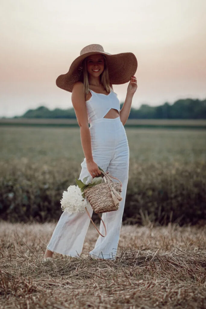 Girl in floppy hat with peeaboo top and loose fitting slacks