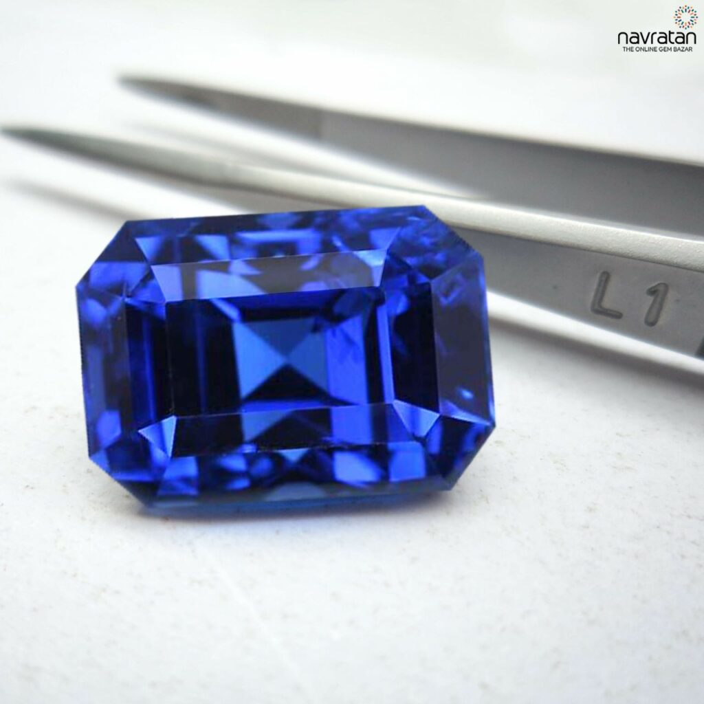 blue sapphire next to tweezers